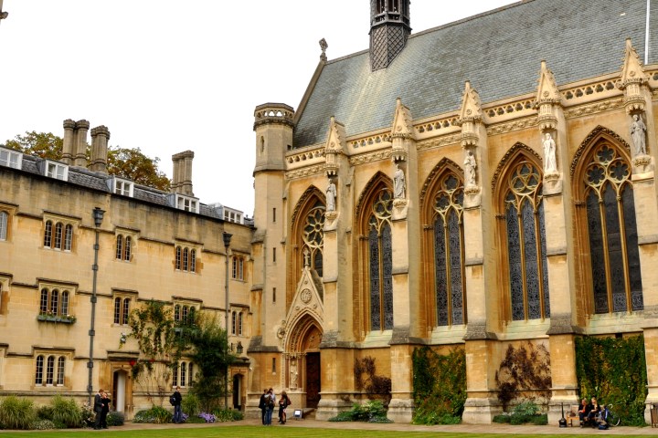 Gothic-style building with pointed arches and green lawn.
