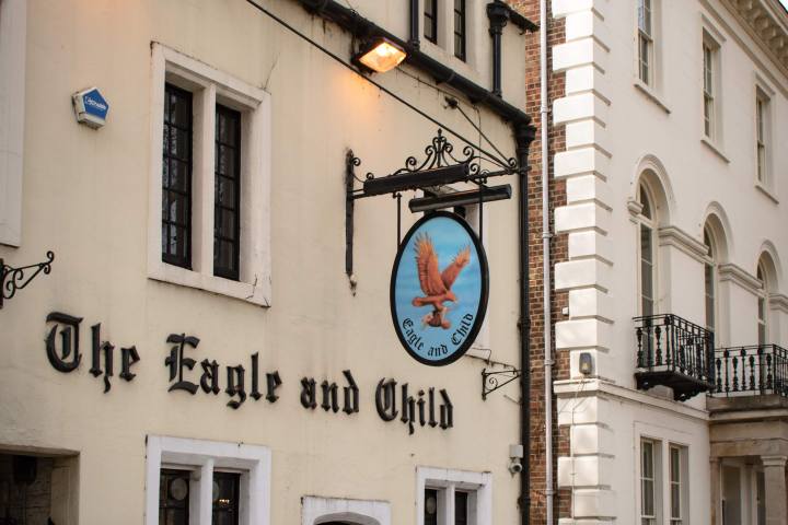 Historic pub 'The Eagle and Child' with a hanging sign on a narrow street.