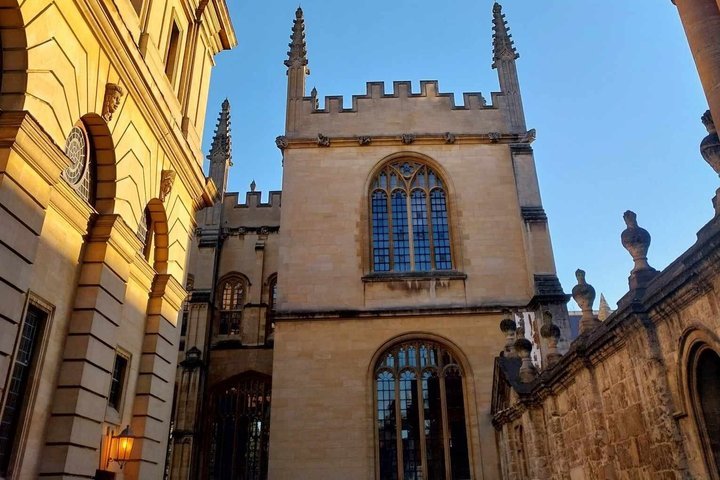 Gothic-style historic building with arched windows and spires under clear blue sky.