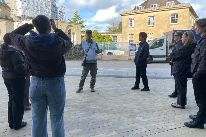 A group of people standing outdoors near a construction site.