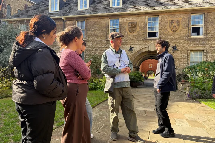 Group of people talking in front of a historic brick building.